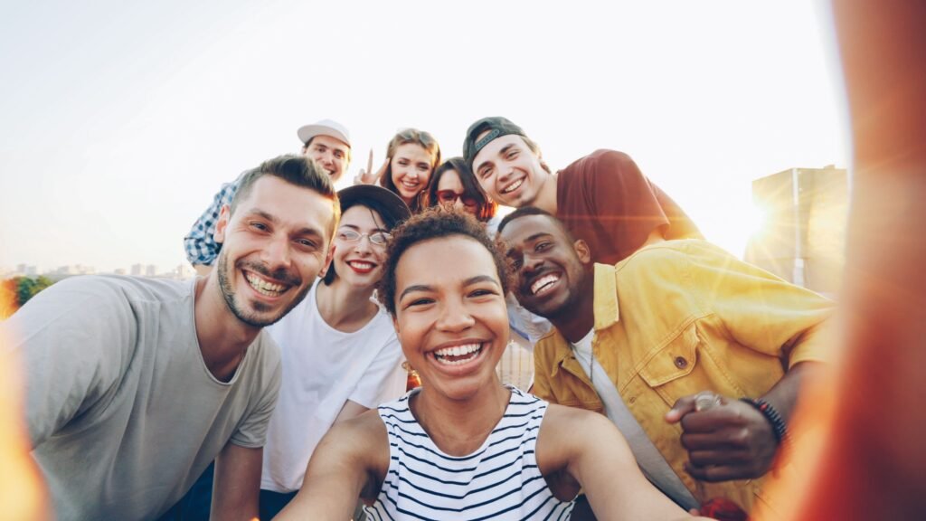 pexels-photo-36729918-36729918 A diverse group of friends taking a joyful selfie outdoors during sunset.