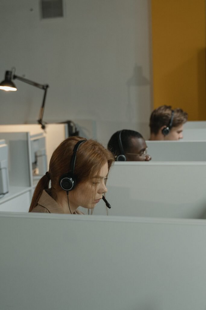 pexels-photo-5453828-5453828-1 Diverse call center agents focused on their tasks in a modern workspace with headsets.
